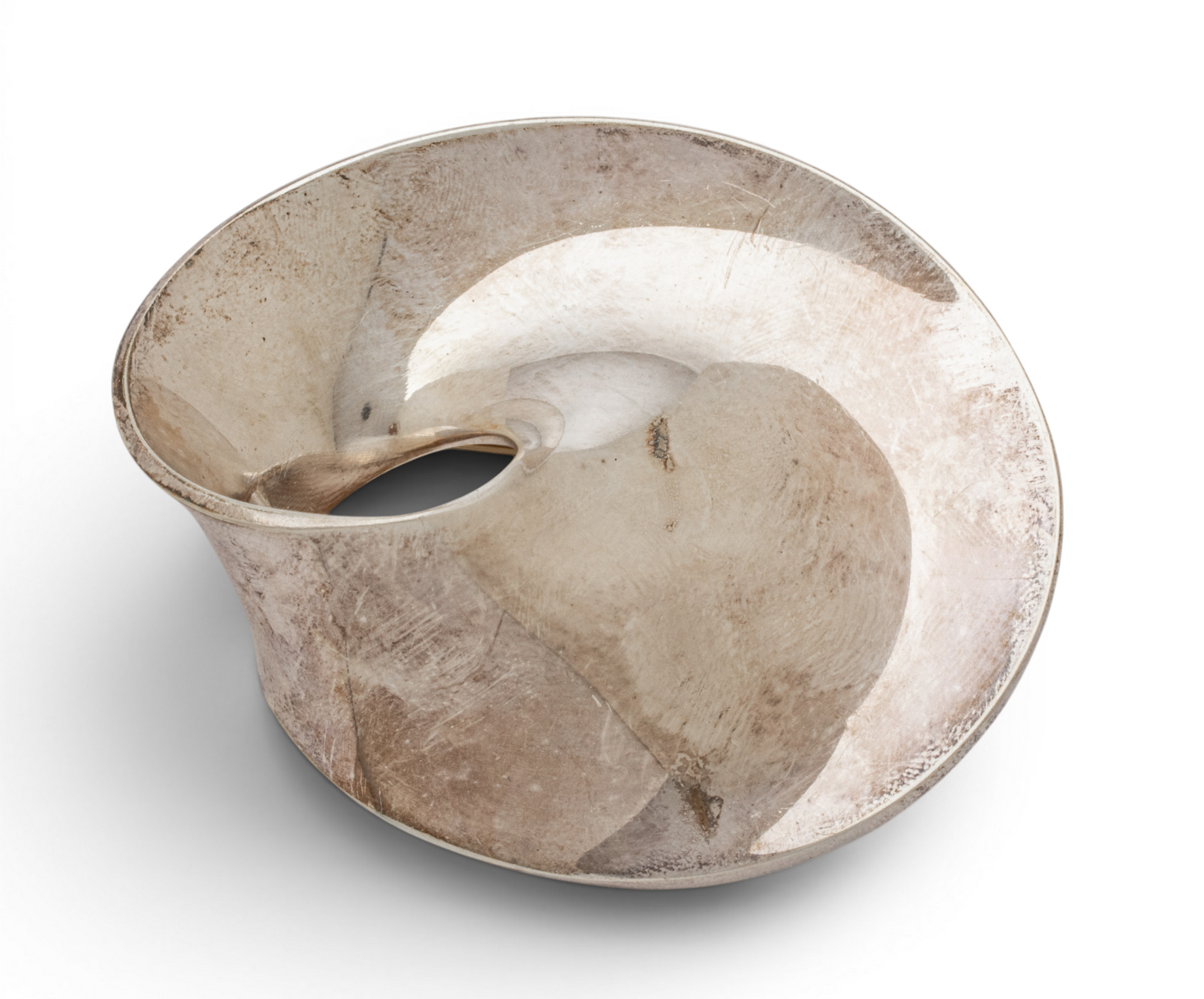 Close-up of a weathered beige metal ring with a rough, scratched surface and circular opening against a white background.