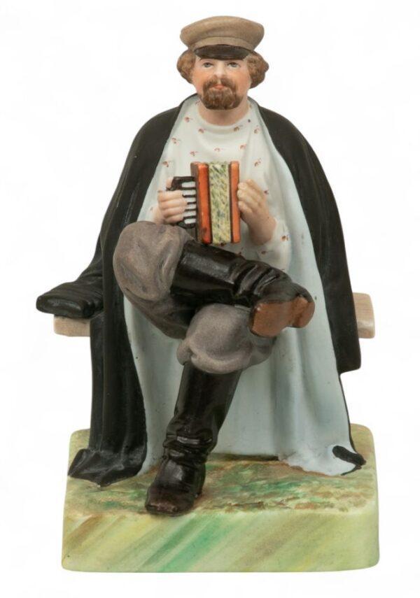Russian Hand Painted Porcelain Figurine 'Accordian Player', H 6.5" W 5" L 5"