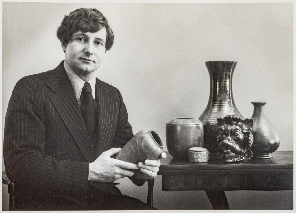 photo of a man holding pottery